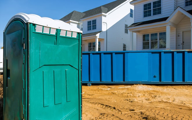 dumpster and portable toilet at a construction site